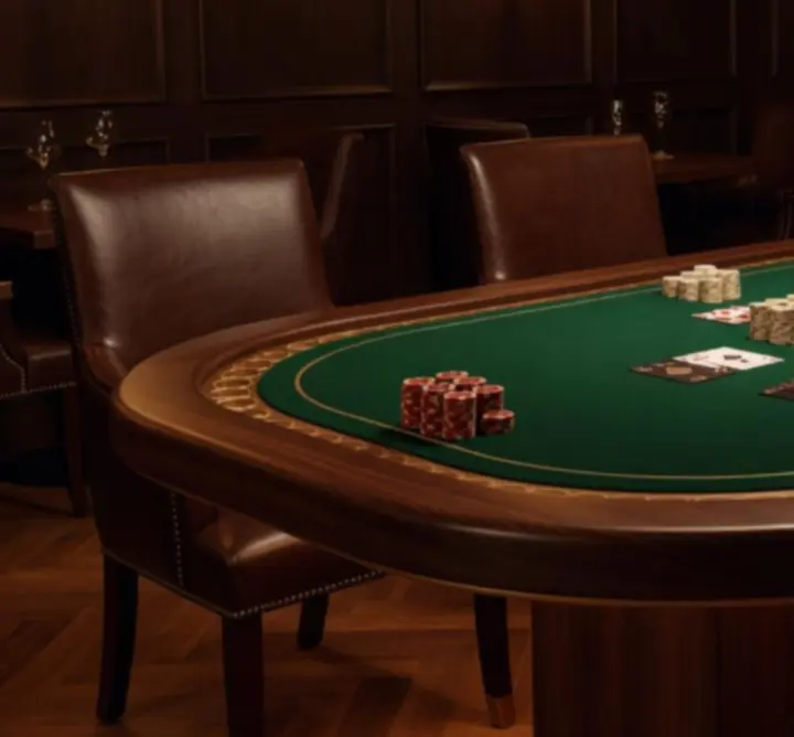 Ekskluzywne wnętrze z pokerowym stołem, miękkimi fotelami i ciepłym oświetleniem